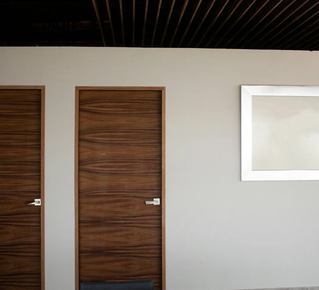 A timber front door set into a pale rendered wall