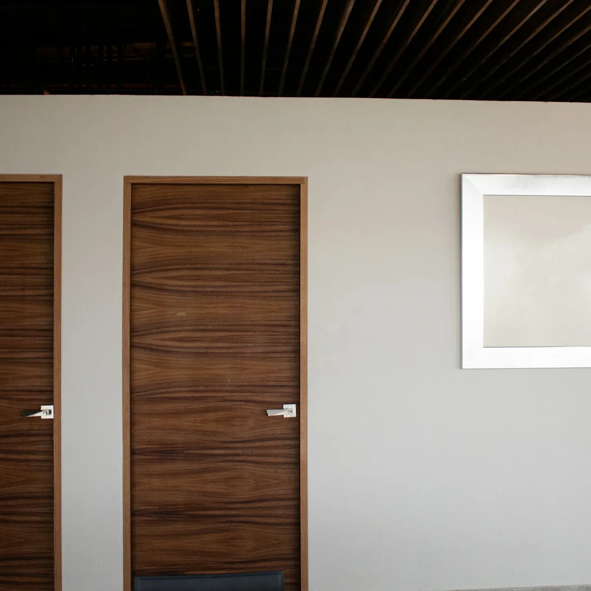 A timber front door set into a pale rendered wall