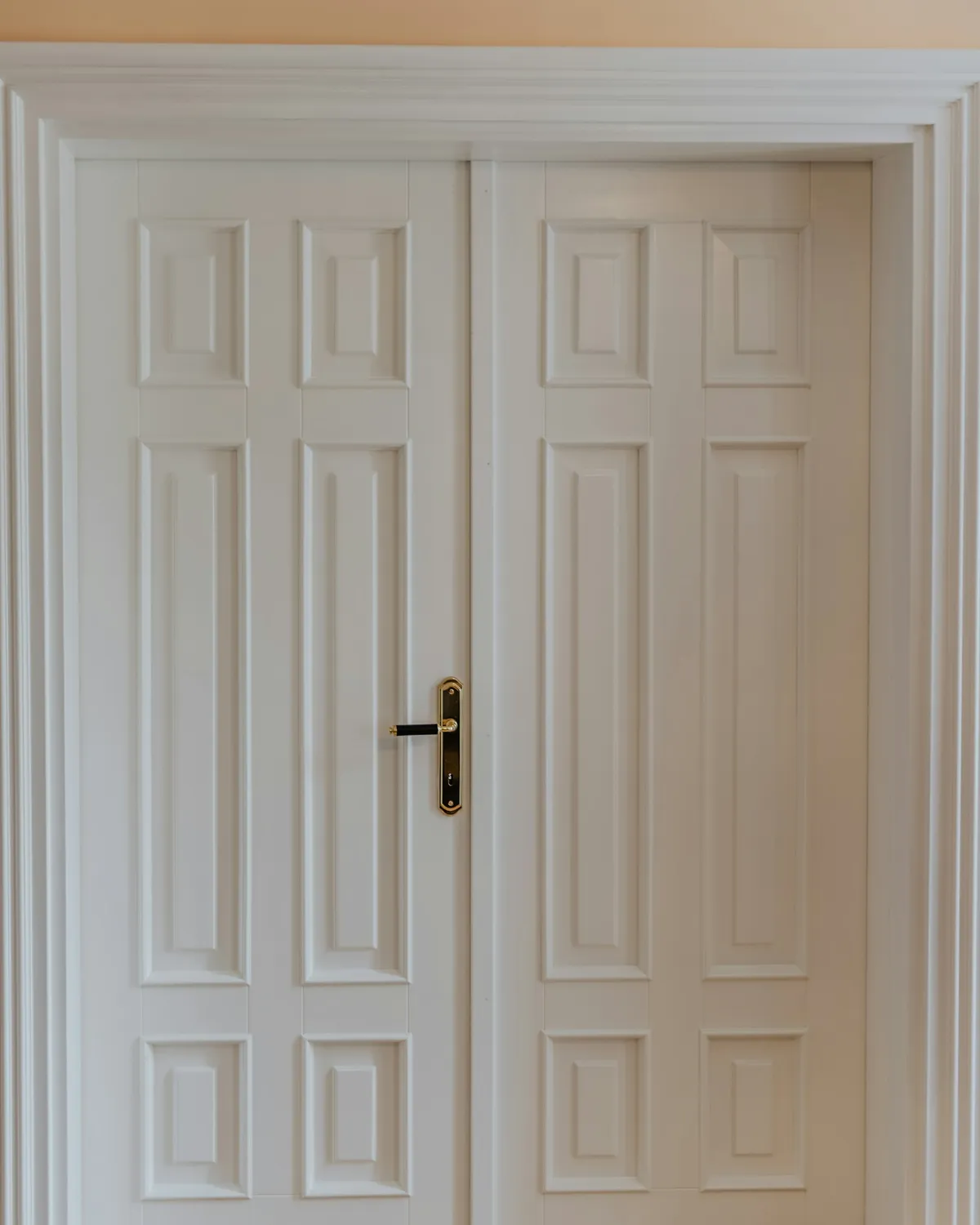 A white six-panel door, closed, in a painted domestic hallway