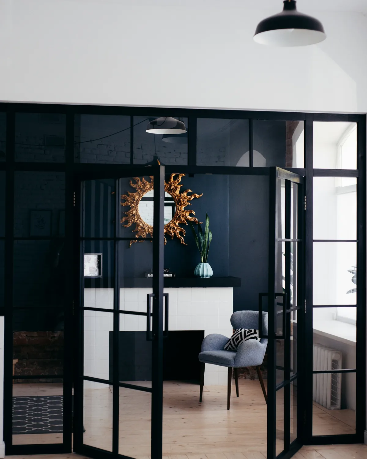 A black panelled door standing ajar, lever handle in the foreground