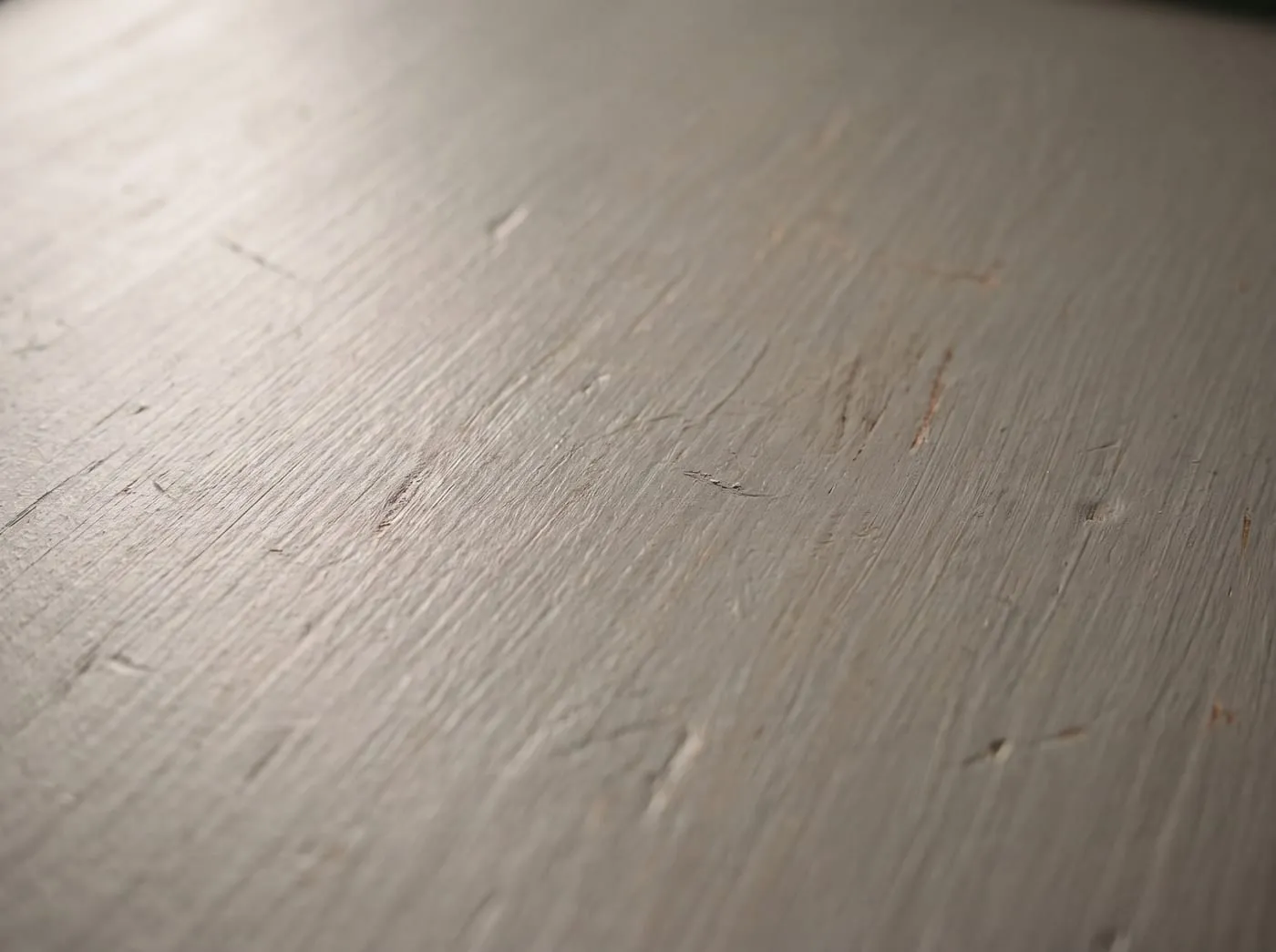 A macro study of a mid-grey painted timber panel with an eggshell sheen