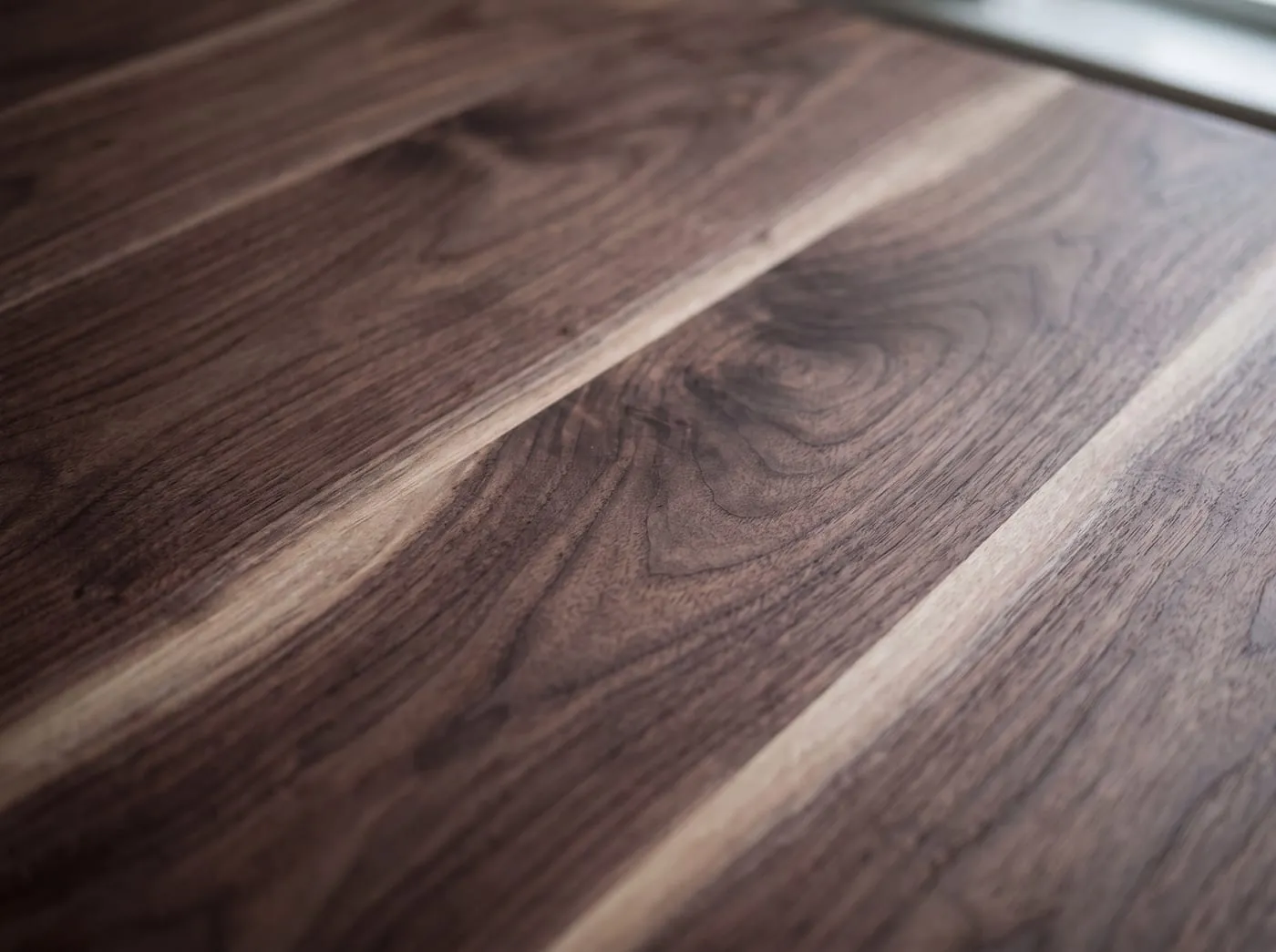 A macro study of American black walnut, dark chocolate grain with paler sapwood streaks